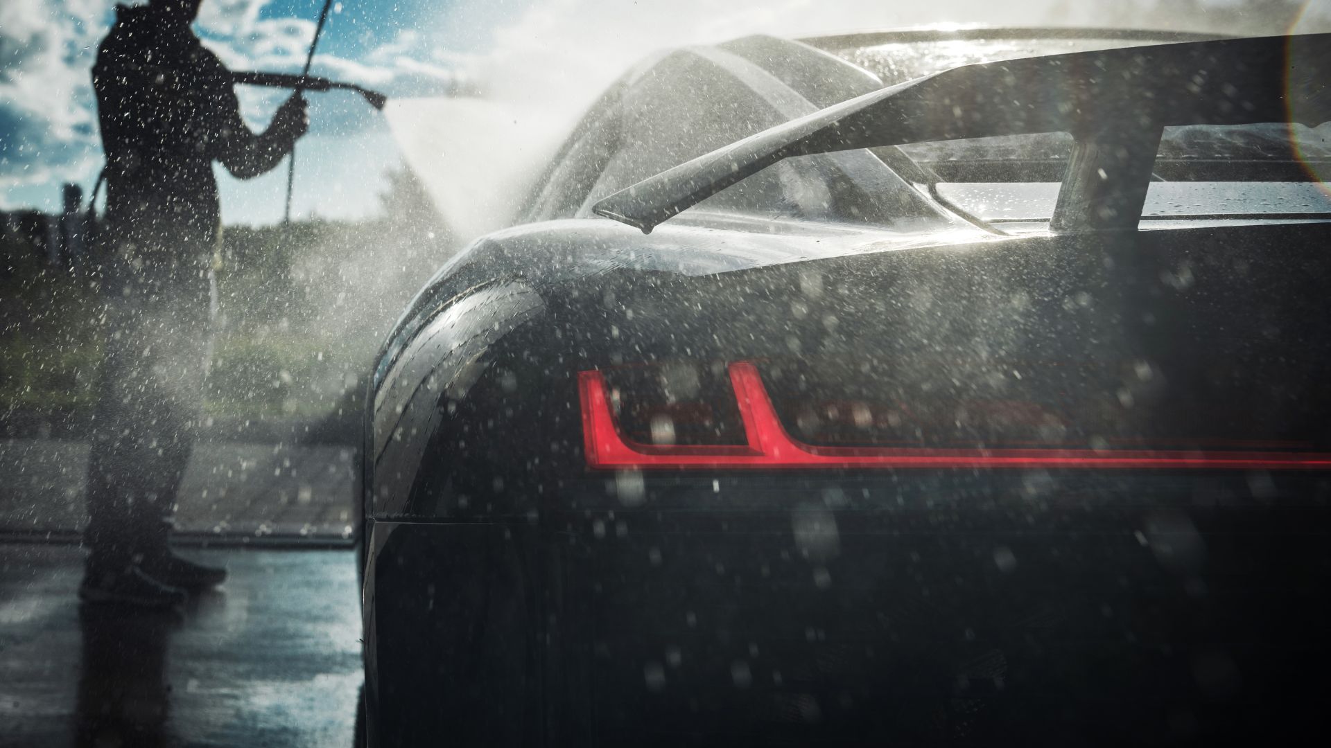 Sleek sports car with red tail light in rainy weather, windshield wipers moving